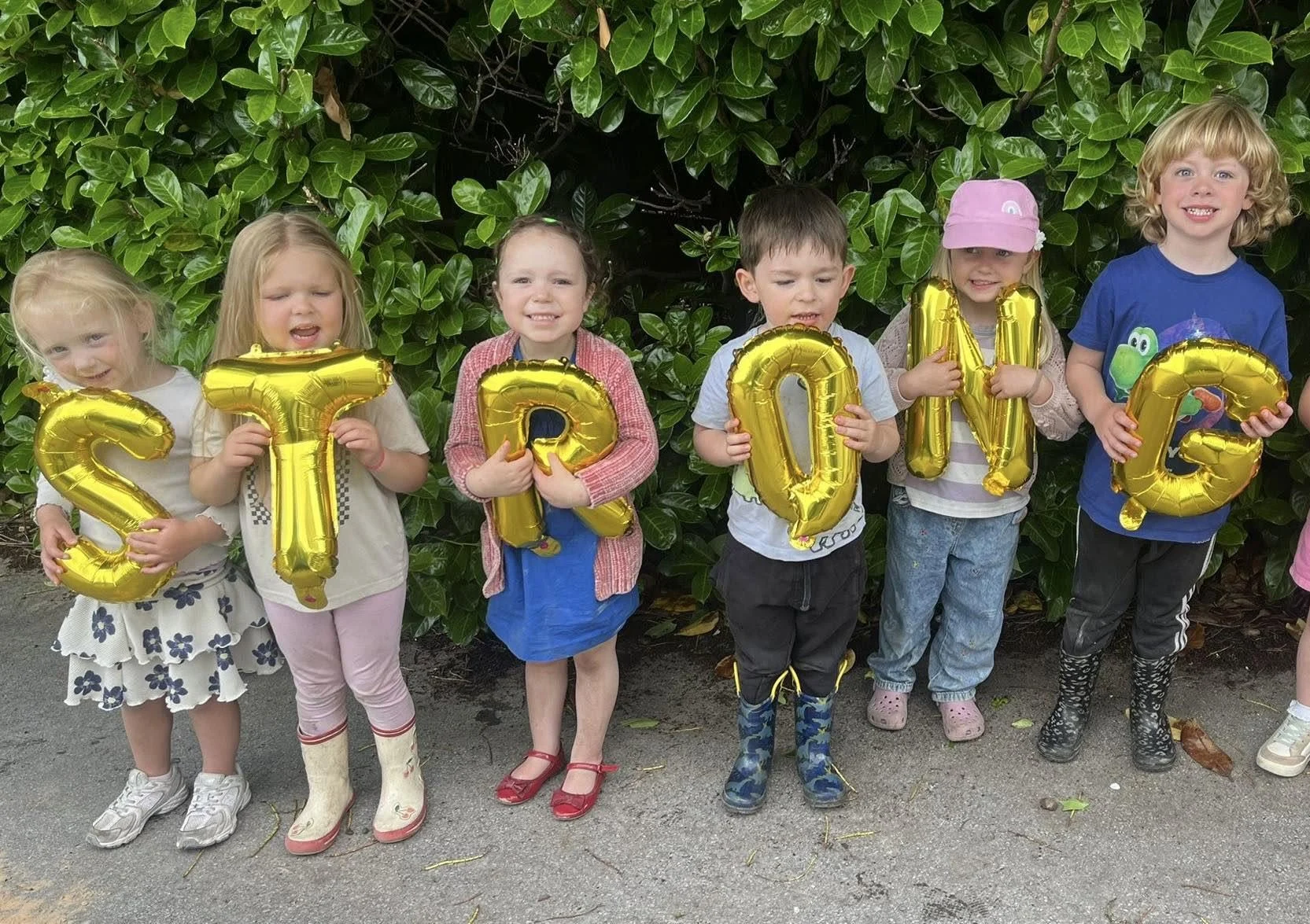 Children at Springfield Farm Day Nursery holding strong letter balloons